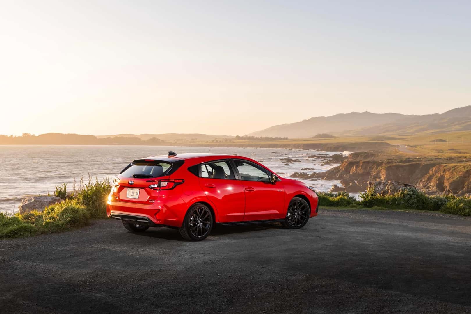 2026 Subaru Impreza Pure Red next to a coastline