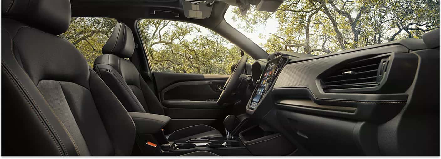 Interior cabin view of the 2026 Subaru Forester showcasing the black upholstery, dashboard, and infotainment system.