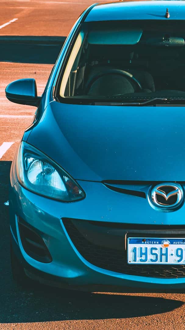 Blue car parked on asphalt with white lines