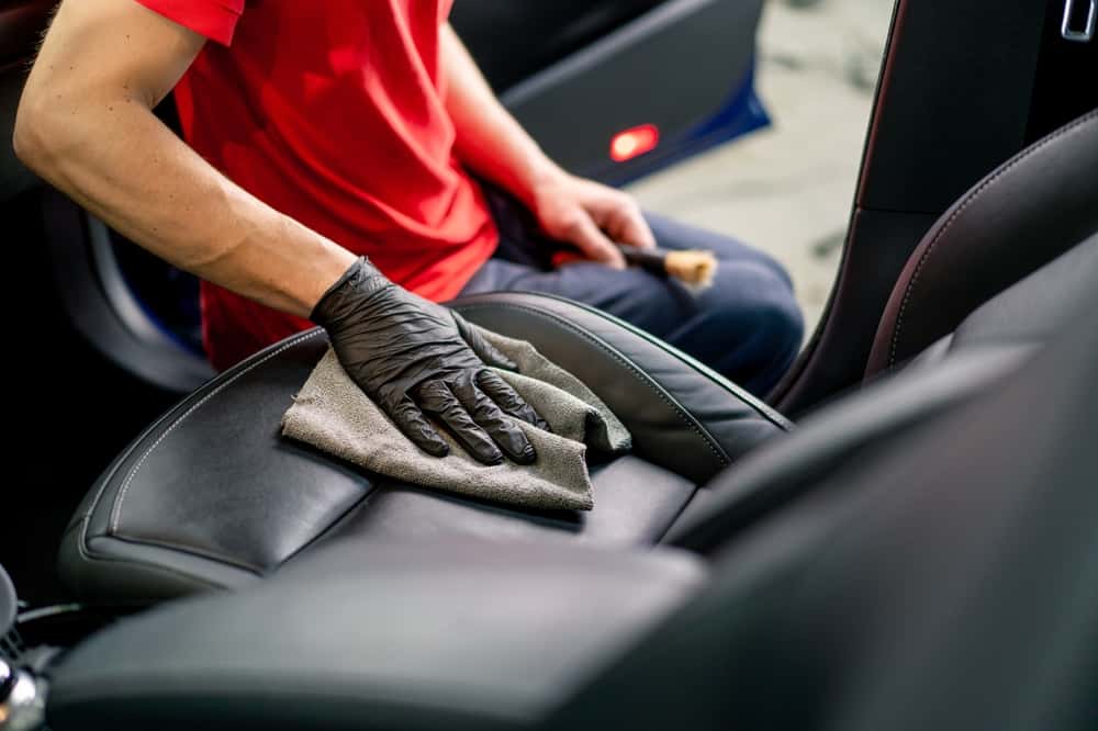 Mechanic showing how to clean vomit from a leather car interior