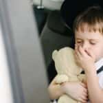 Young child in a car seat feeling car sick