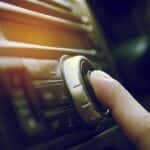 Finger pushing the button on a car stereo
