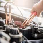 Man Attaching Jumper Cables to Battery Terminals