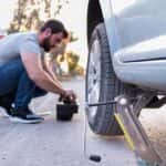 Man Changing a Tire Outdoors