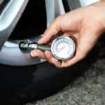 Man Checking Air Pressure on Tires