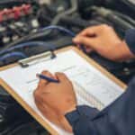 Man Inspecting a Vehicle for Regular Maintenance