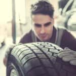 Man Looking at a Car Tire