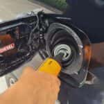 Man putting fuel additive into a diesel tank