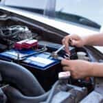 Man tightening nuts and bolts on a car battery