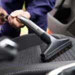 Man vacuuming a driver's seat