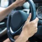 Man's hands on steering wheel