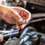 Person Changing a Sparkplug in a Car Engine