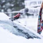 Person Scraping Ice Off a Windshield