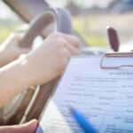 Teenager taking a driving test with hands on the wheel