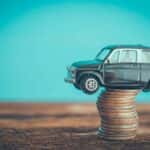 Tiny Car Sitting on a Stack of Dimes