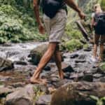 Two People Hiking Near a Stream