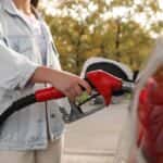 Woman pumping gas into her car