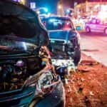 Wrecked Cars on a City Street at Night