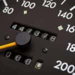 Closeup of analog speedometer with odometer in the middle