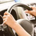 teenager's hands on a car steering wheel