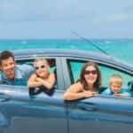 Happy family on vacation at the beach in a car