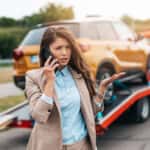 Woman calling the Collision Center while the vehicle is towed
