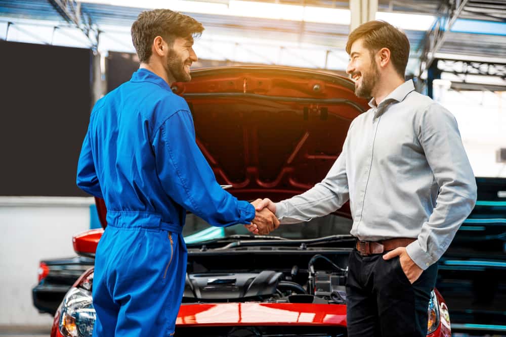 Customer shaking hands with a car maintenance technician