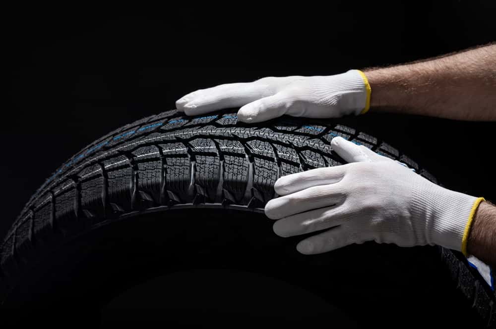Close-up of a mechanic’s hands changing winter tires