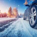 Close-up view of a car’s winter tires on a snowy road