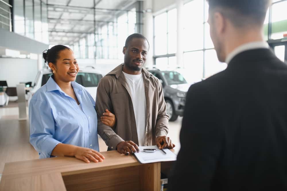 A couple finalizing a sale at a vehicle dealership