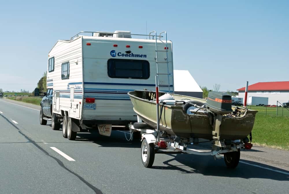 Used truck towing a camper and a boat