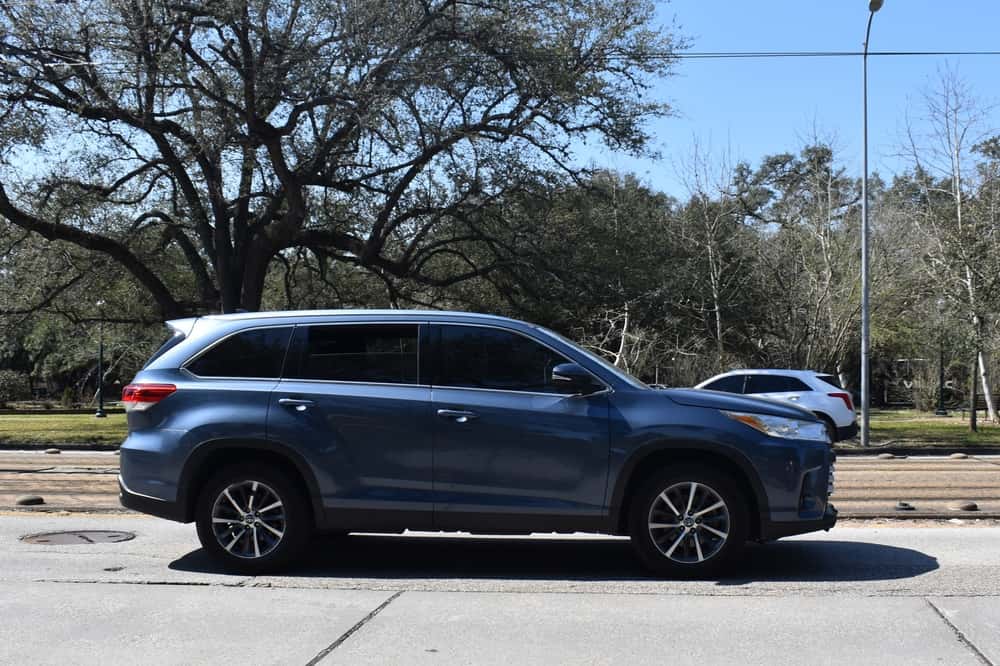 A blue Toyota Highlander used SUV driving down the road