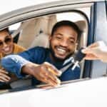 A couple driving away after financing a used vehicle