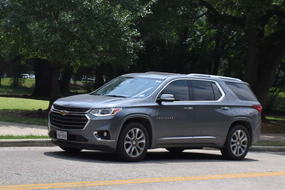 A gray Chevrolet Traverse used SUV on a residential street