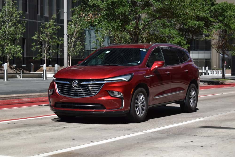 A red Buick Enclave used SUV parked on the side of the road