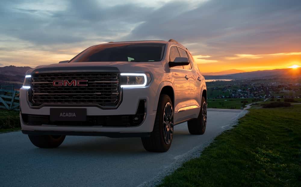 A white GMC Acadia at sunset