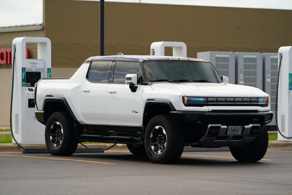 A white GMC Hummer EV at an EV charging station