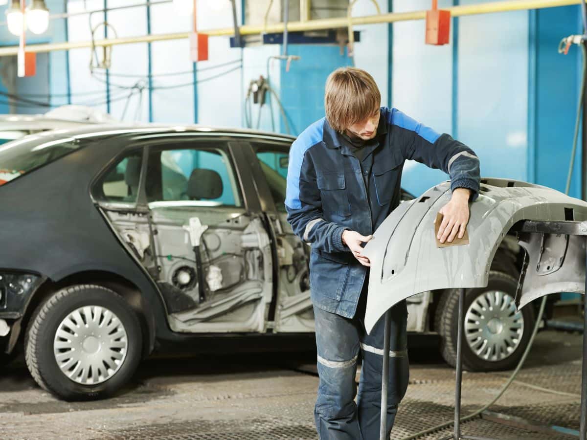 technician fixing car bumper