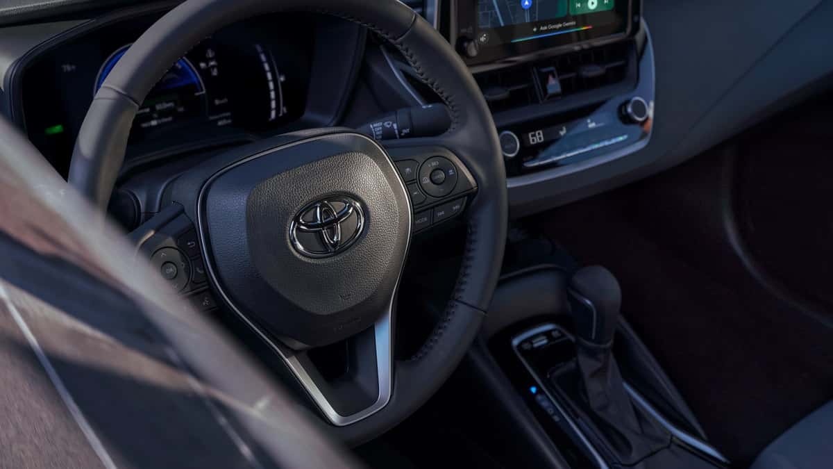 2026 Toyota Corolla Hybrid interior with steering wheel, hybrid gauge cluster and center console
