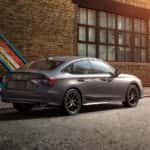 2027 honda civic sedan parked in front of brick building