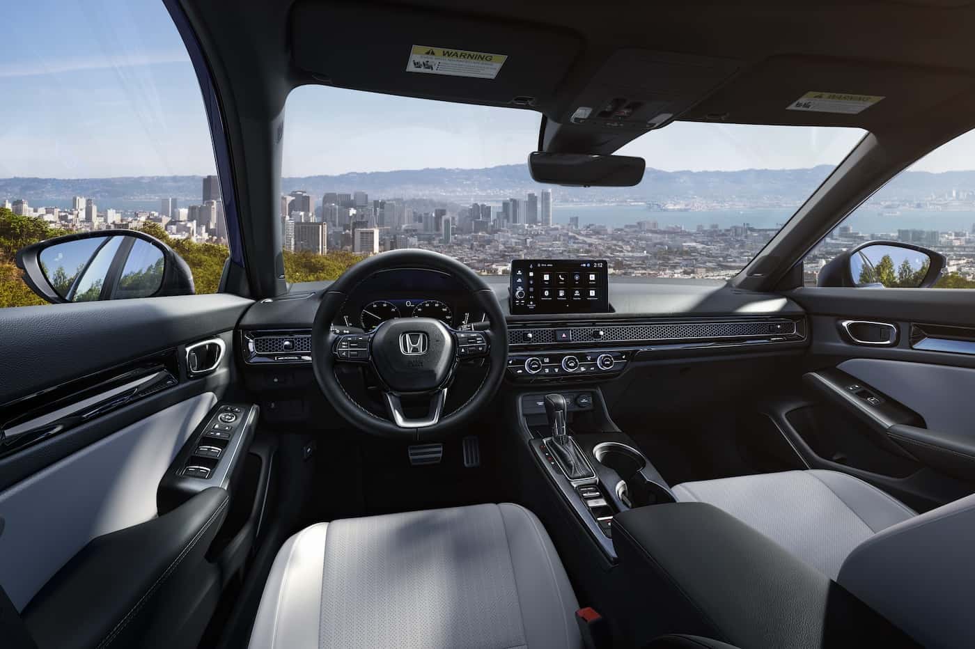 Wide view of the Honda Civic Sedan dashboard and steering wheel from the front seats