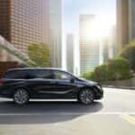 2027 honda odyssey side exterior profile driving through intersection in city