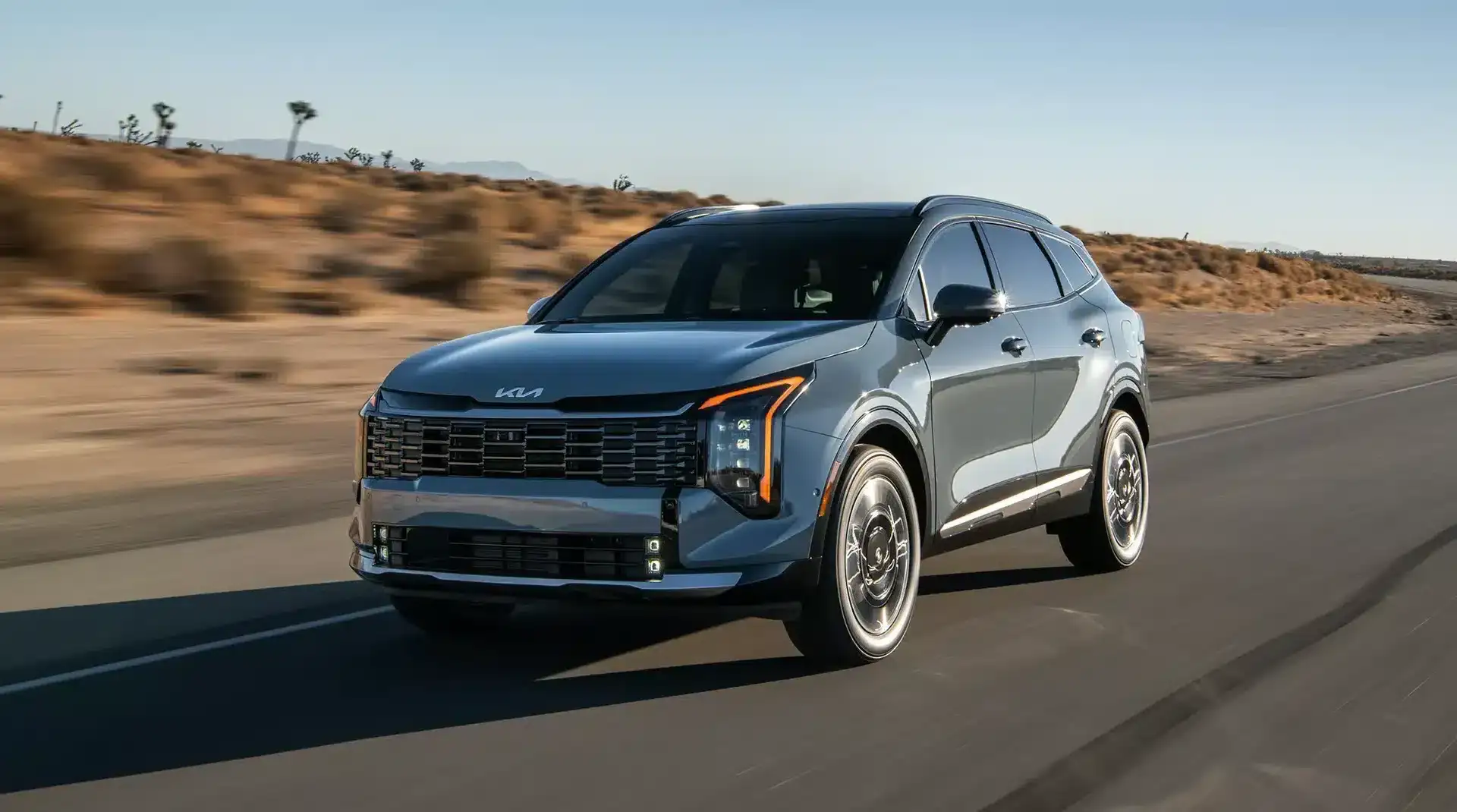 2026 Kia Sportage Hybrid exterior profile on a scenic road.