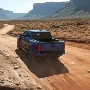 2025 Toyota Tacoma Blue Rear View Driving on a Dirt Path