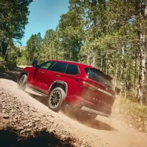 2026 Toyota Sequoia Supersonic Red driving uphill