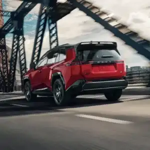 2026 Toyota RAV4 PHEV GR Sport Supersonic Red with a black roof in motion