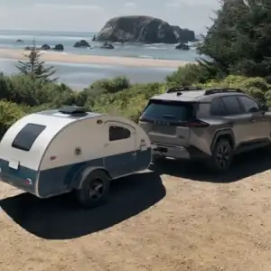 2026 Toyota RAV4 PHEV Woodland Urban Rock towing a camper