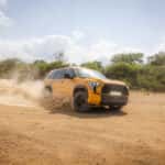 2027 toyota sequoia driving through a desert with plumes of dirt flying up behind