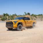 2027 toyota tundra driving through desert with plumes of dirt coming up the sides in honeycomb color