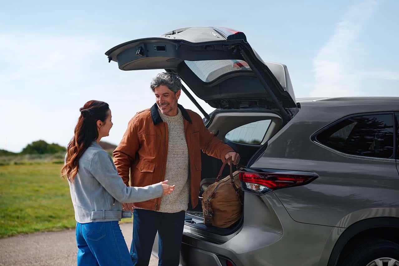 Loading luggage into the cargo area of a 2026 Toyota Highlander Hybrid